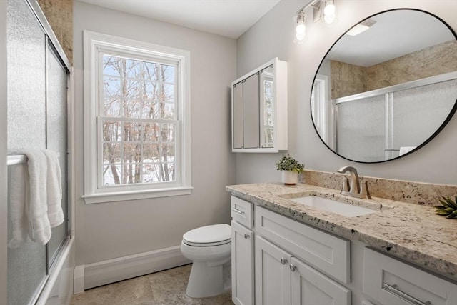 bathroom featuring a wealth of natural light, baseboards, toilet, and vanity