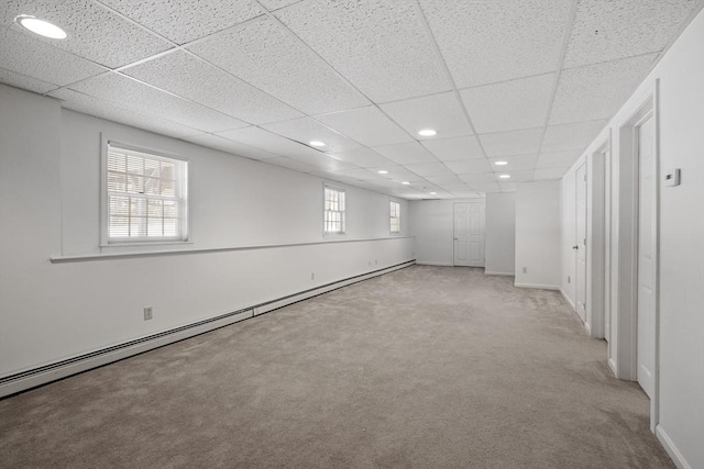 unfurnished room with a baseboard heating unit, baseboards, a drop ceiling, carpet floors, and recessed lighting