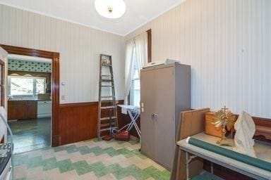 miscellaneous room with wood walls and ornamental molding