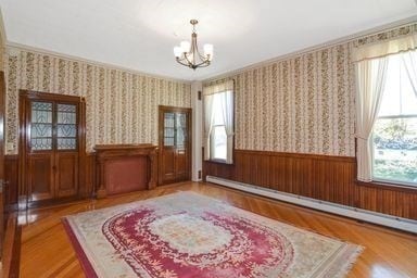 sitting room with a chandelier, light hardwood / wood-style flooring, and a baseboard heating unit