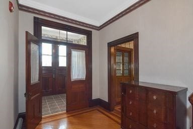 entryway with french doors, wood-type flooring, and ornamental molding