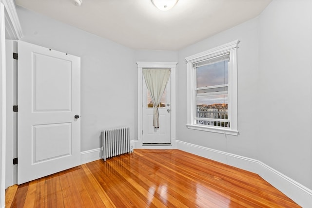 unfurnished room with wood-type flooring and radiator