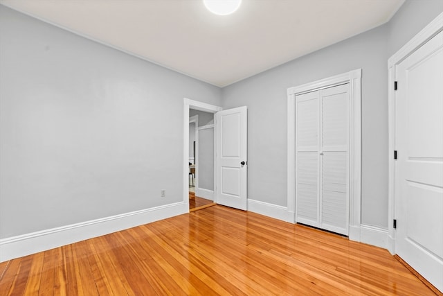 unfurnished bedroom with light hardwood / wood-style flooring and a closet