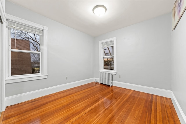 empty room with radiator and hardwood / wood-style floors