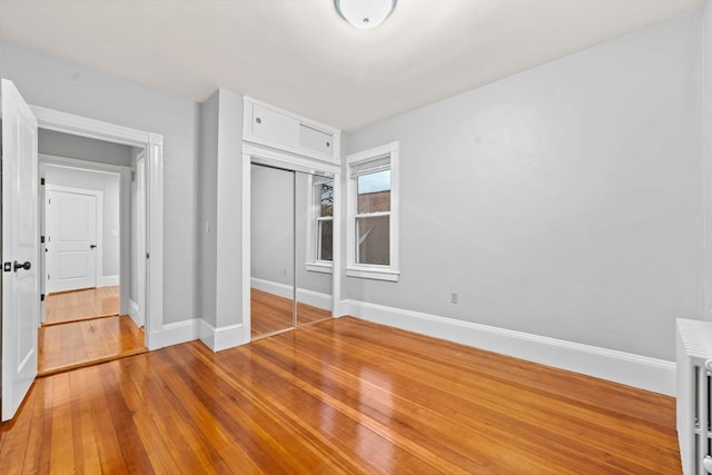 unfurnished bedroom with light hardwood / wood-style floors and a closet