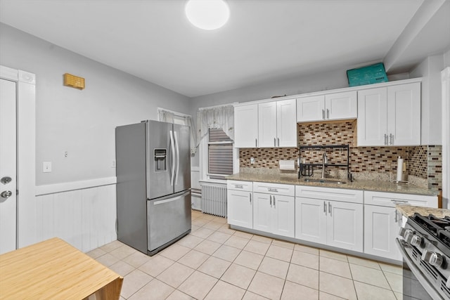 kitchen with white cabinets, sink, light stone counters, and stainless steel appliances