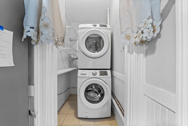 washroom featuring stacked washing maching and dryer and light tile patterned floors