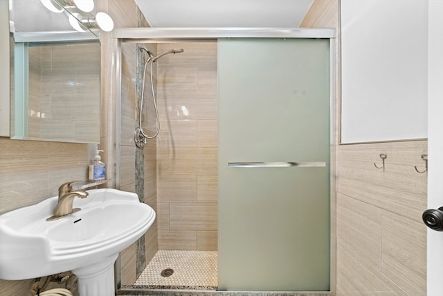 bathroom featuring walk in shower, tile walls, and sink