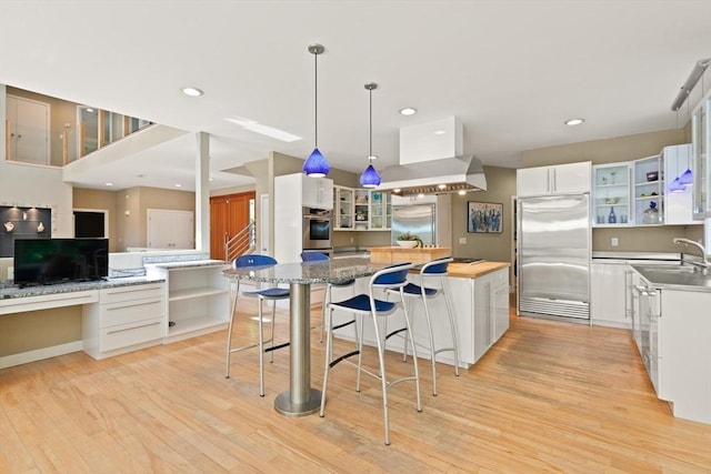28 Elm St, Berkley, MA 02779 - kitchen featuring stainless steel appliances, open shelves, island range hood, light wood finished floors, and a spacious island