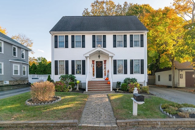 colonial-style house featuring a front yard