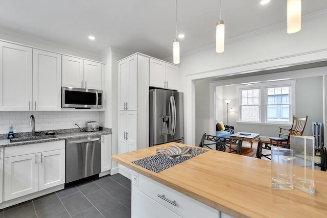 137 Freeman St Unit 3A, Brookline, MA 02446 - kitchen featuring stainless steel appliances, a sink, tasteful backsplash, ornamental molding, and dark tile patterned floors