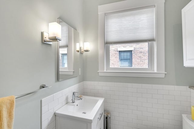 137 Freeman St Unit 3A, Brookline, MA 02446 - bathroom with tile walls, vanity, a wainscoted wall, toilet, and radiator