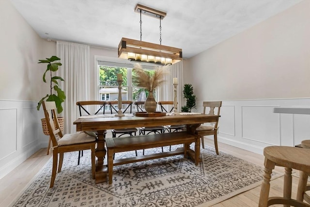 27 Harnden Rd, Billerica, MA 01821 - dining space featuring a decorative wall, light wood-style floors, wainscoting, and a chandelier