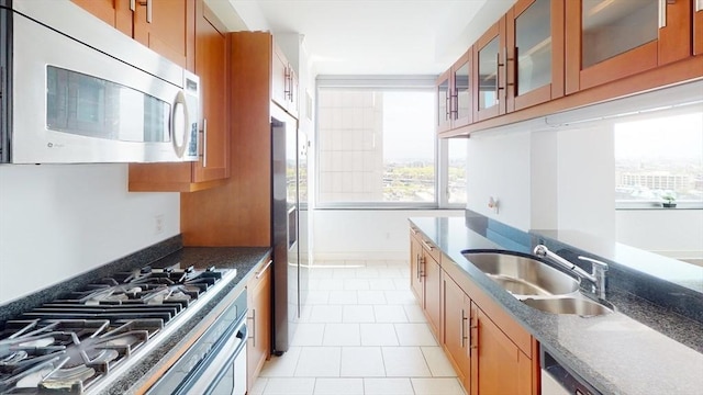 kitchen with appliances with stainless steel finishes, light tile patterned floors, and sink