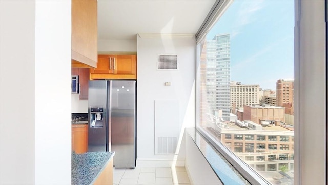 kitchen featuring stainless steel refrigerator with ice dispenser and light tile patterned floors