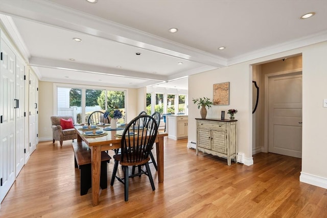 dining room with beam ceiling, light hardwood / wood-style flooring, and ornamental molding