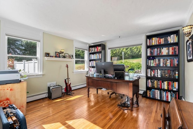 office space with a baseboard heating unit and light hardwood / wood-style floors