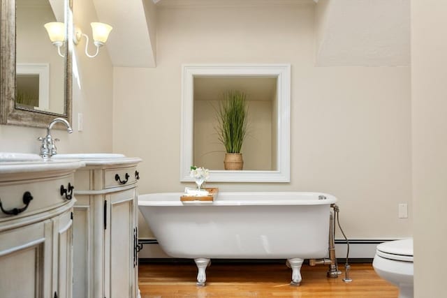 bathroom with toilet, wood-type flooring, and a bath