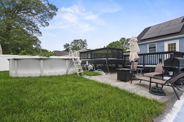 51 Crystal St, Lowell, MA 01852 - view of green lawn featuring a wooden deck, an outdoor pool, and a patio area