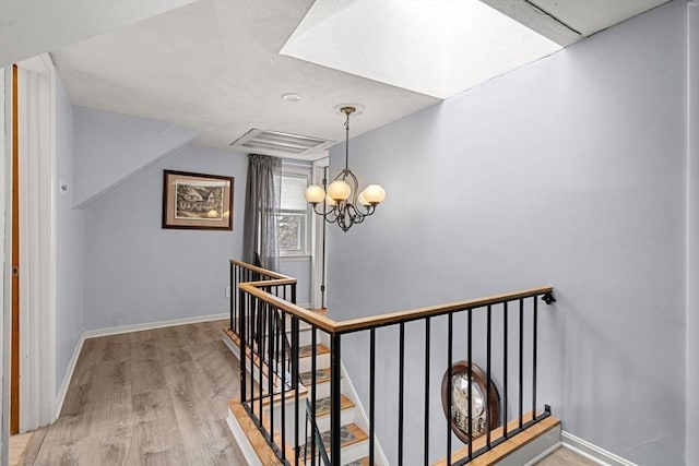65 Holten St, Danvers, MA 01923 - stairway with a chandelier, wood finished floors, and baseboards