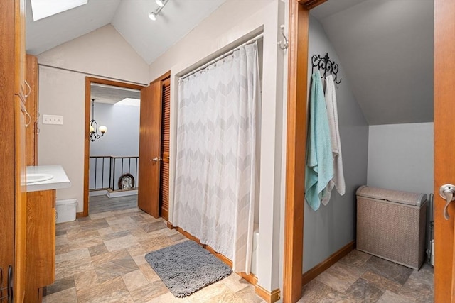 65 Holten St, Danvers, MA 01923 - full bathroom featuring lofted ceiling, vanity, stone finish flooring, baseboards, and shower / tub combo with curtain