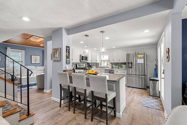 65 Holten St, Danvers, MA 01923 - kitchen featuring appliances with stainless steel finishes, light wood finished floors, baseboards, recessed lighting, and backsplash