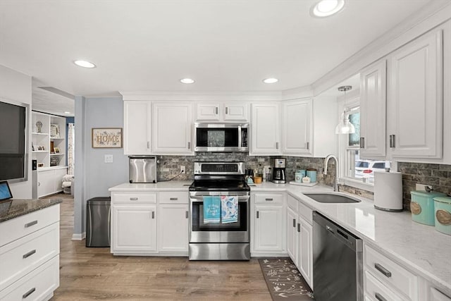 65 Holten St, Danvers, MA 01923 - kitchen with appliances with stainless steel finishes, a sink, white cabinets, decorative backsplash, and recessed lighting