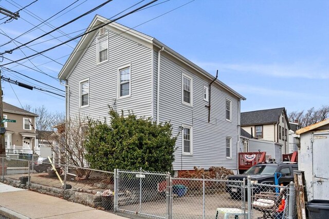 view of side of home featuring a gate and a fenced front yard