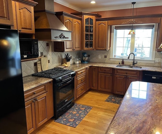 kitchen with sink, black appliances, light hardwood / wood-style floors, and light stone countertops