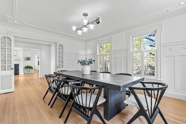 dining room featuring a decorative wall, ornamental molding, light wood-type flooring, a chandelier, and recessed lighting