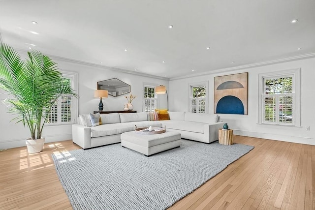 living area featuring ornamental molding, healthy amount of natural light, hardwood / wood-style flooring, recessed lighting, and baseboards
