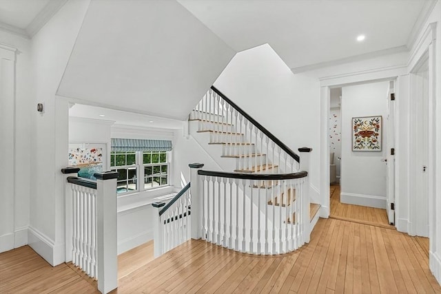 stairs with hardwood / wood-style flooring, baseboards, and ornamental molding