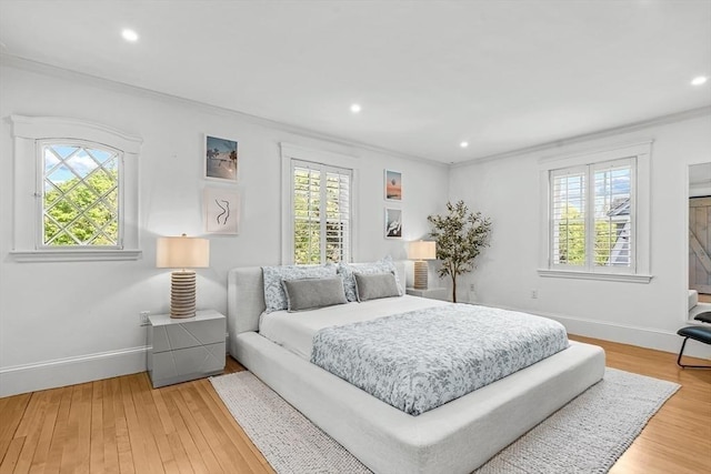 bedroom featuring multiple windows, ornamental molding, baseboards, wood finished floors, and recessed lighting