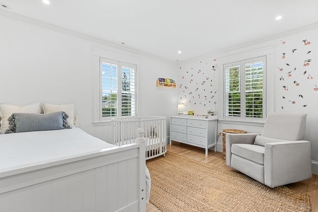 bedroom featuring multiple windows, light wood finished floors, ornamental molding, and recessed lighting