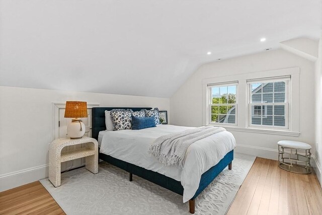 bedroom featuring lofted ceiling, wood finished floors, baseboards, and recessed lighting