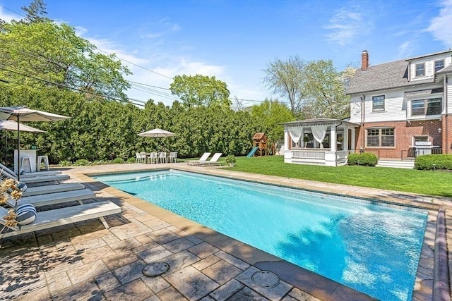 swimming pool featuring a playground, a patio, a yard, and a gazebo