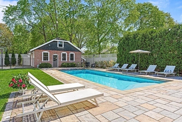 view of swimming pool featuring a patio area, an outbuilding, fence, and a storage structure