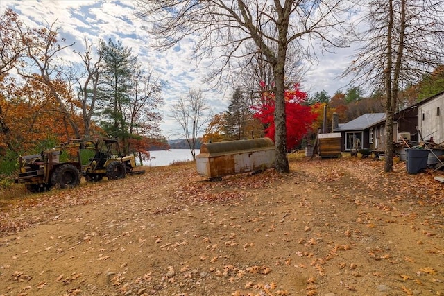 view of yard featuring a water view and a storage shed