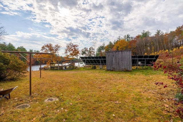 view of yard featuring a water view and an outbuilding