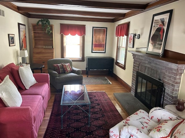 202 Madison St, Dedham, MA 02026 - living area featuring plenty of natural light, beam ceiling, a brick fireplace, wood finished floors, and baseboards