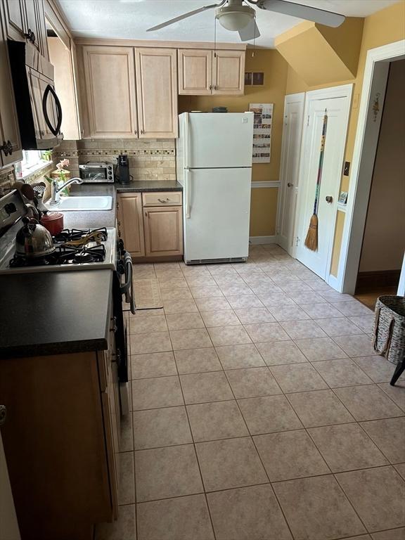 202 Madison St, Dedham, MA 02026 - kitchen with freestanding refrigerator, a ceiling fan, gas range, dark countertops, and a sink