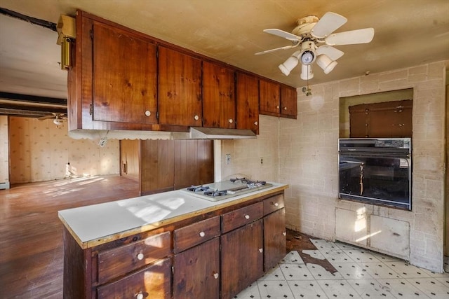 kitchen featuring black oven, white gas cooktop, and ceiling fan