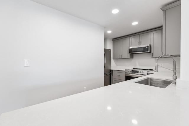 kitchen featuring gray cabinetry, sink, and stainless steel appliances