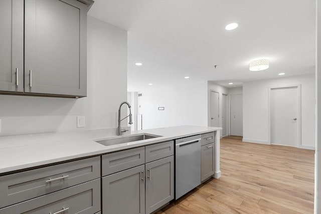 kitchen with sink, gray cabinets, light hardwood / wood-style floors, and dishwasher