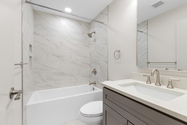 full bathroom with tiled shower / bath, vanity, and toilet