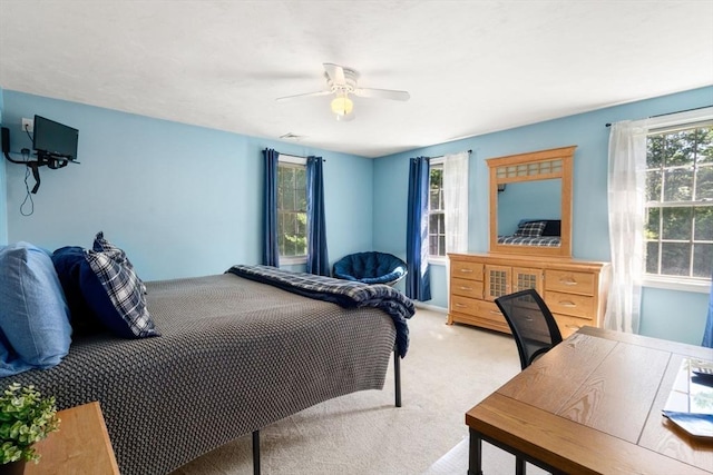 bedroom with visible vents, a ceiling fan, and light colored carpet