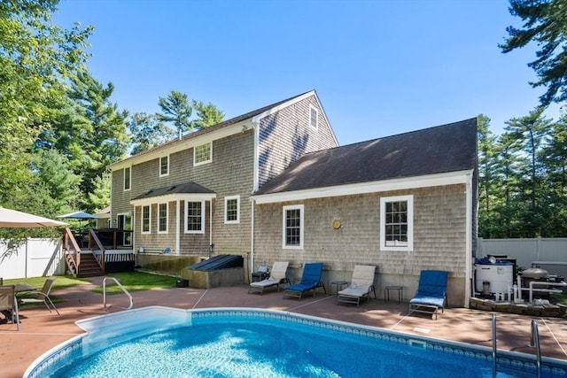 rear view of house featuring a patio, fence, a fenced in pool, and a wooden deck