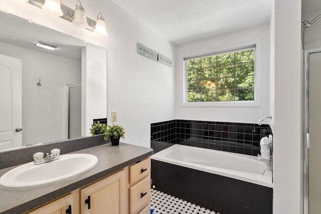 bathroom featuring a garden tub, a shower stall, and vanity