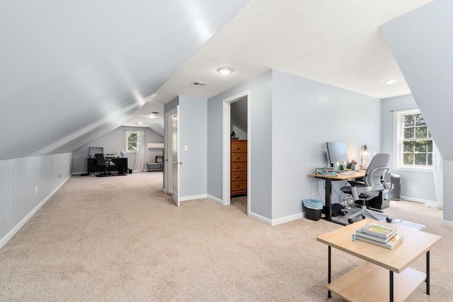 interior space featuring lofted ceiling, visible vents, and baseboards