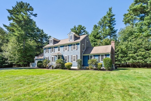 view of front facade featuring a chimney and a front lawn